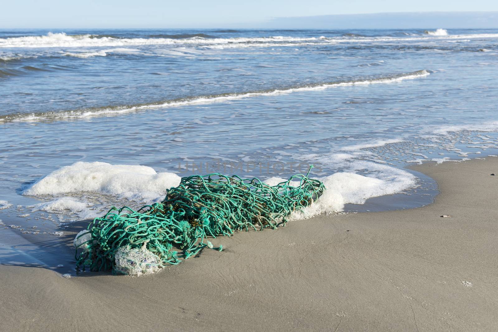 Green fishing net on the North Sea Beach of the island of Terschelling in the North of the Netherlands
