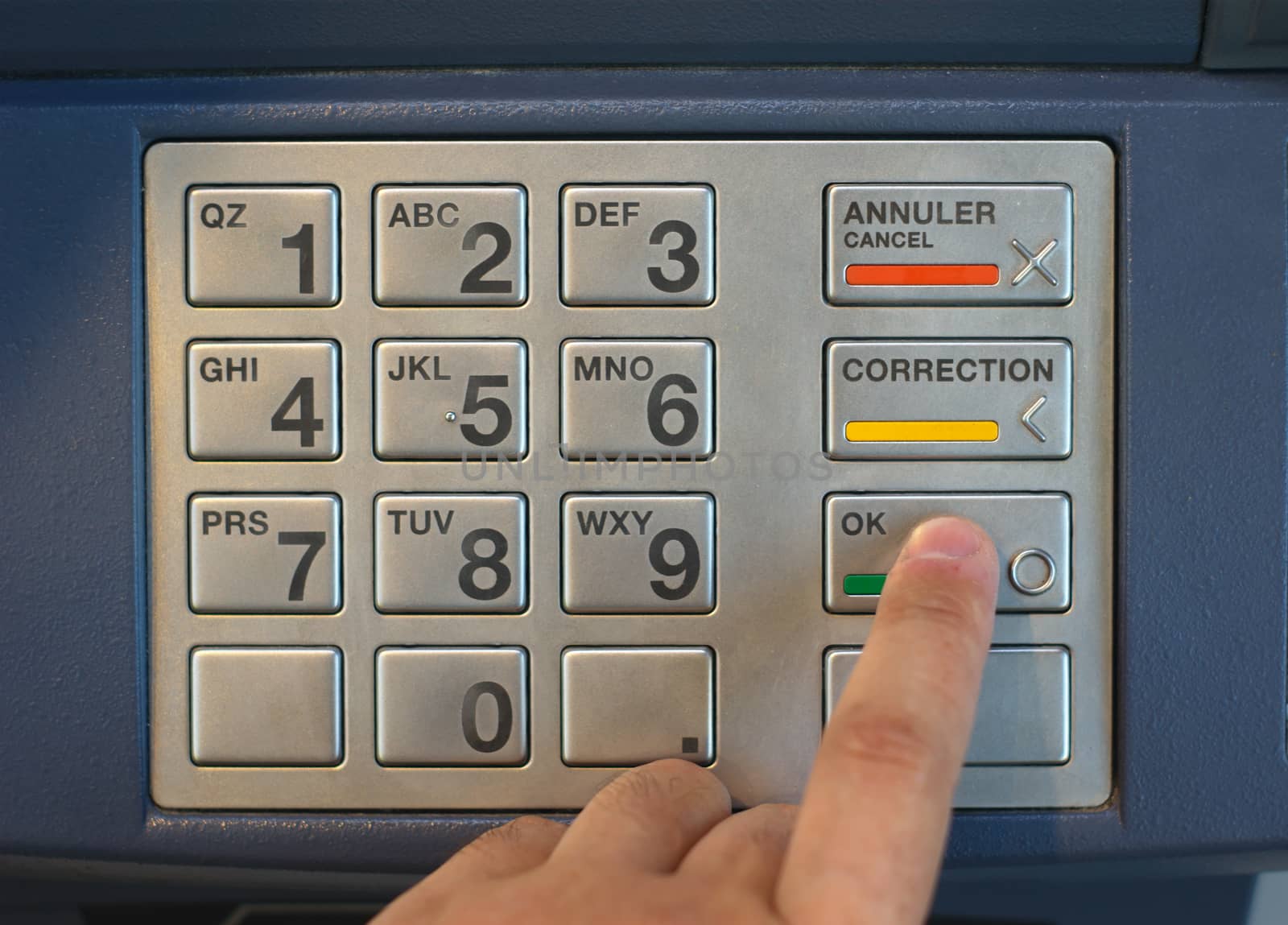 finger pressing buttons on cash machine to enter nip code on the keypad