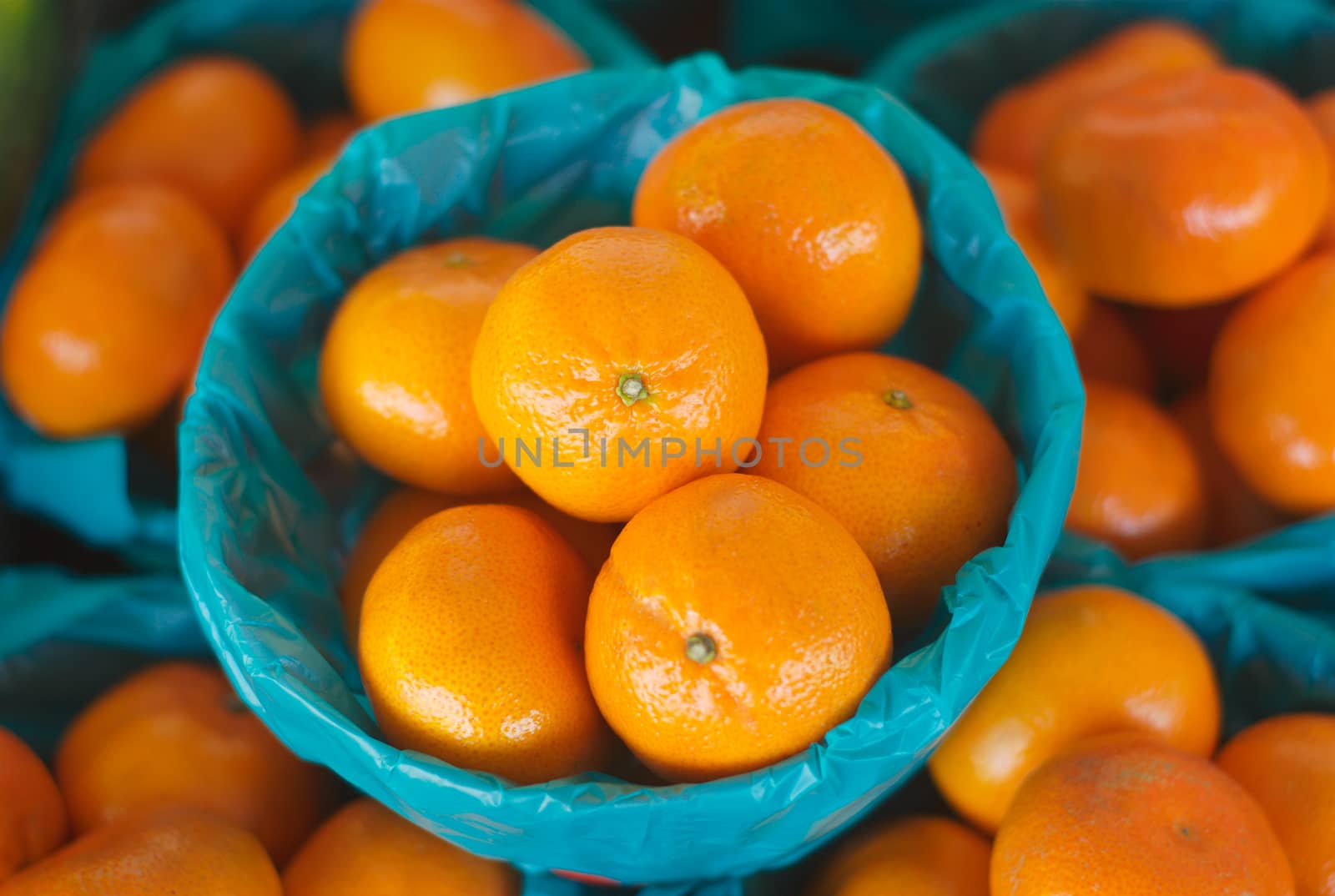 many orange clementines at the market in a basket