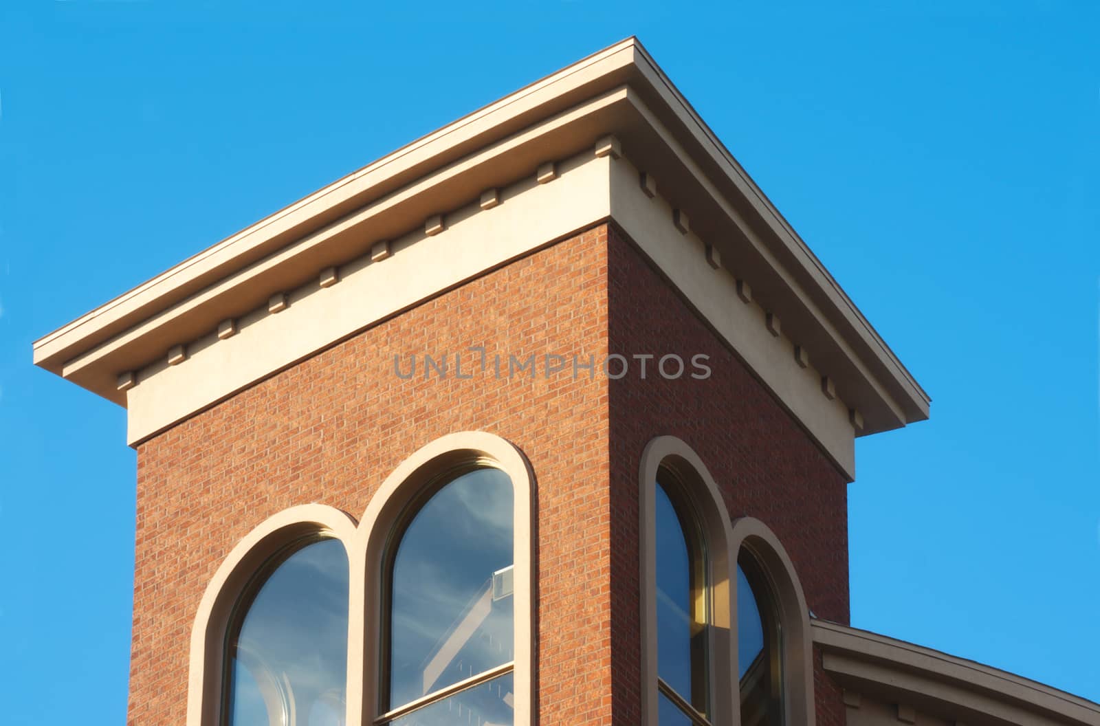 building top stair case in brick with rounded windows on blue sky