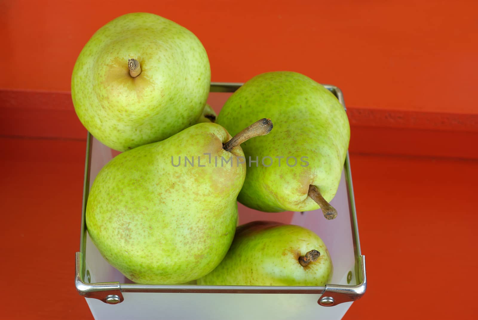 green yellow pears fruits at the market on red background