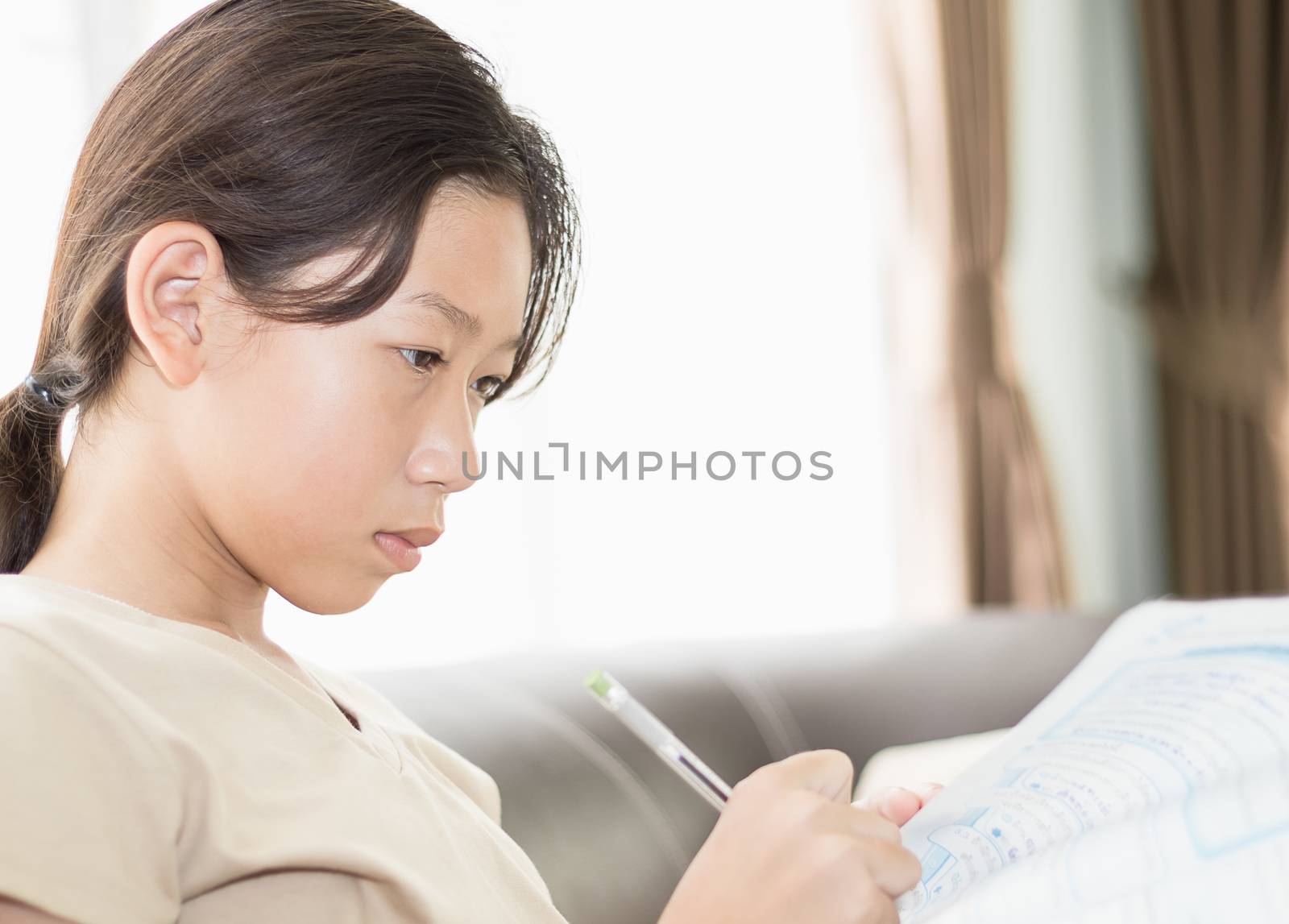 Asian girl writing on lesson book by stoonn