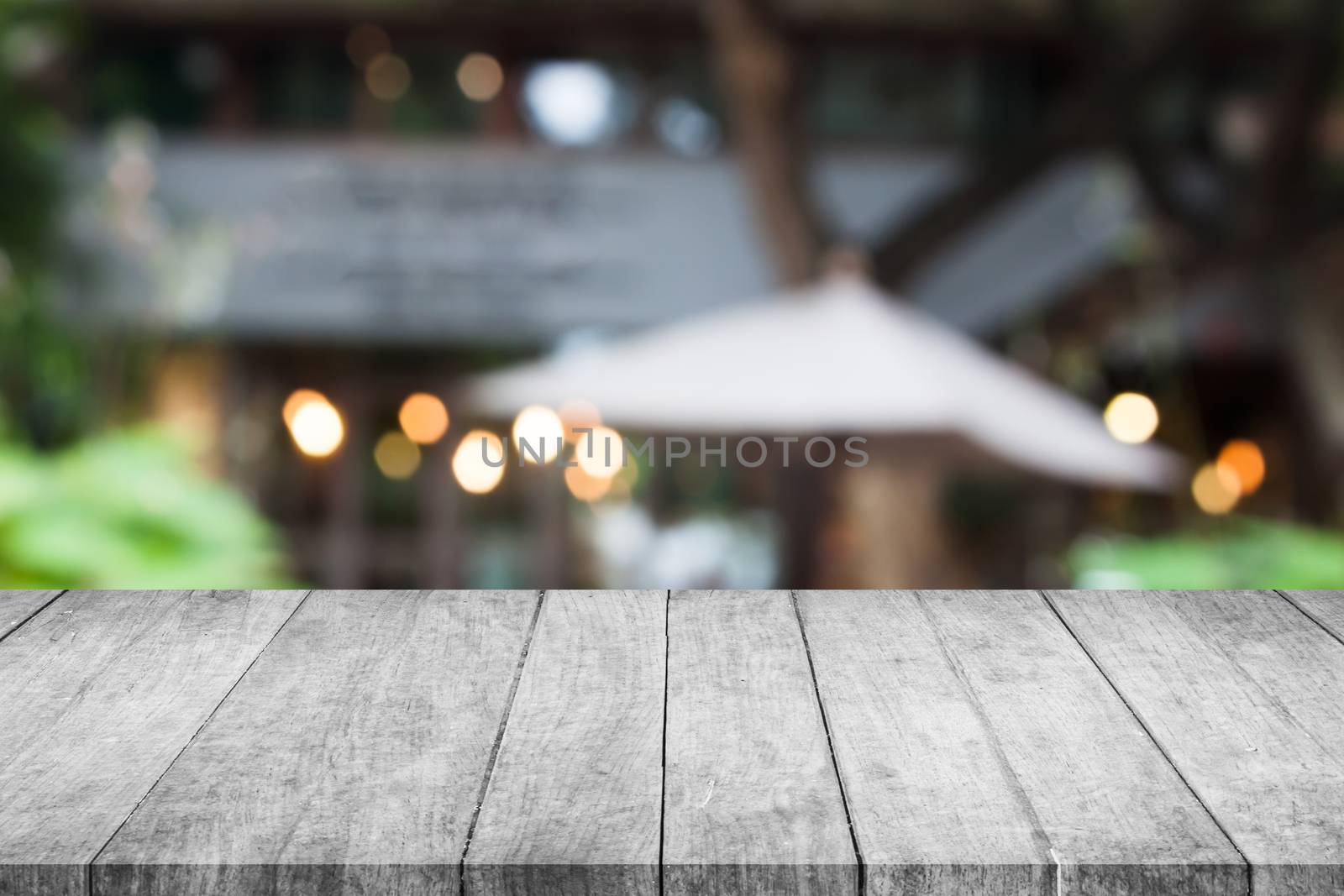 Perspective grey wooden table top with cafe blurred abstract background