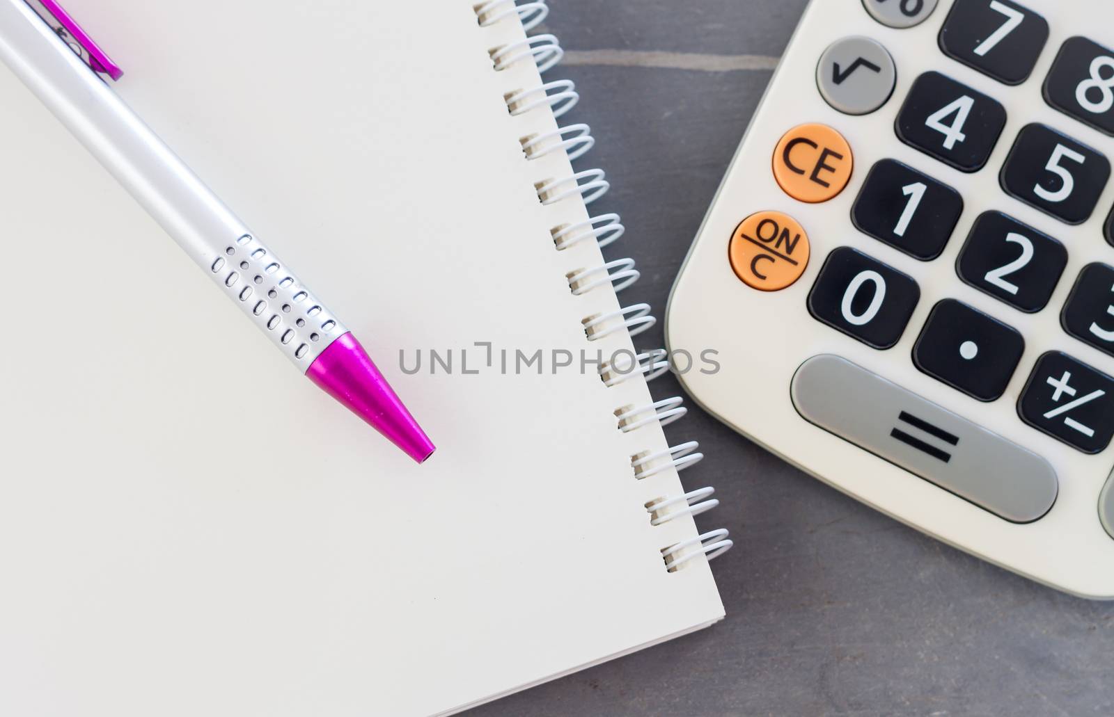 Calculator, notepad and pen on grey background, stock photo