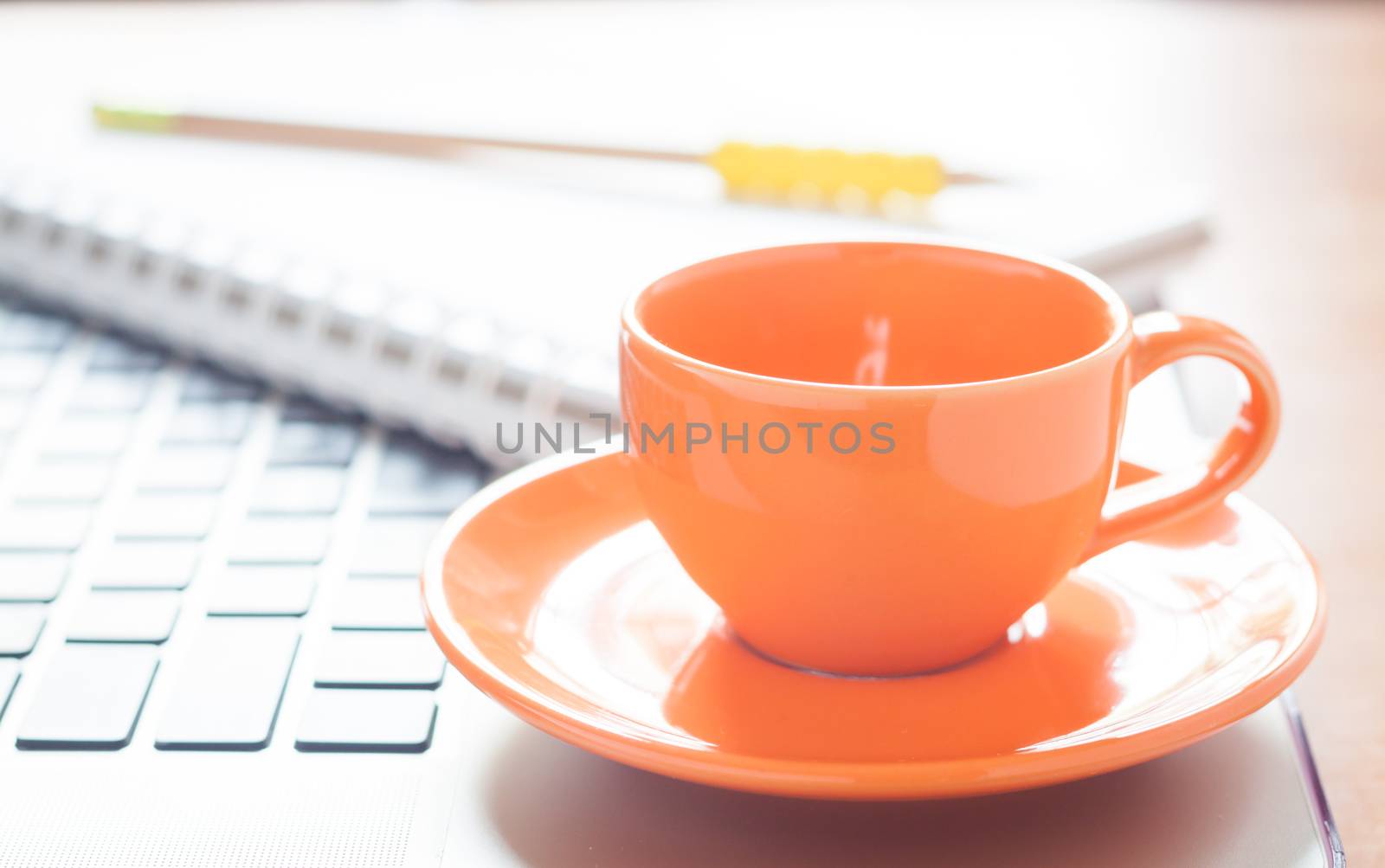 Laptop with coffee cup and notepad on desk, stock photo