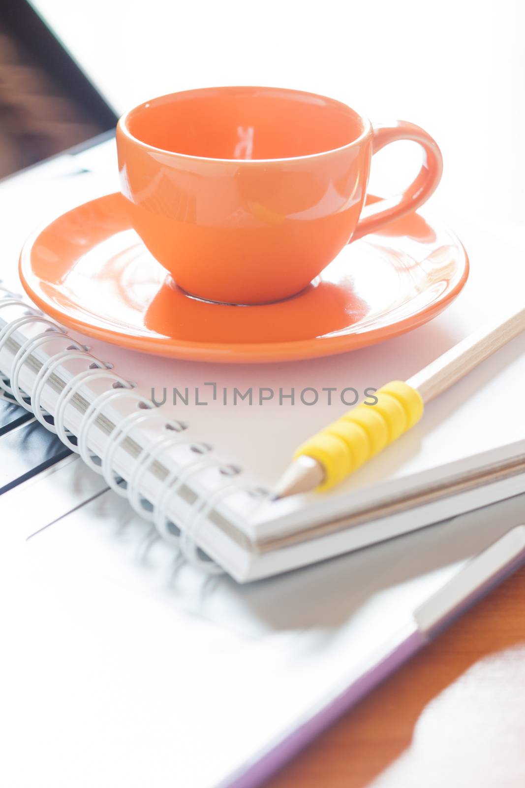 Laptop with coffee cup and notepad on desk, stock photo