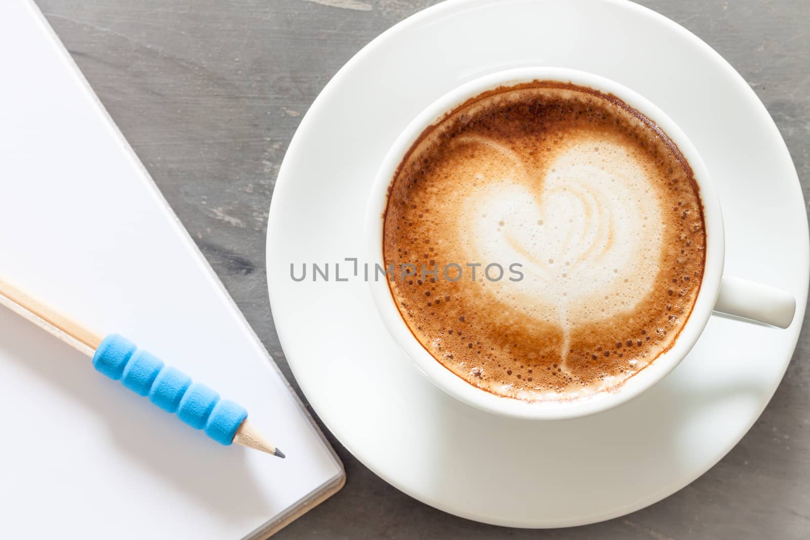 Coffee cup with notepad on grey background, stock photo