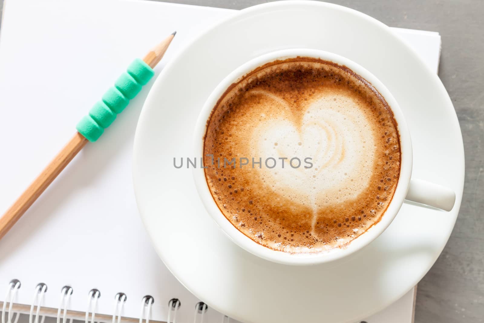 Coffee cup with notepad on grey background, stock photo