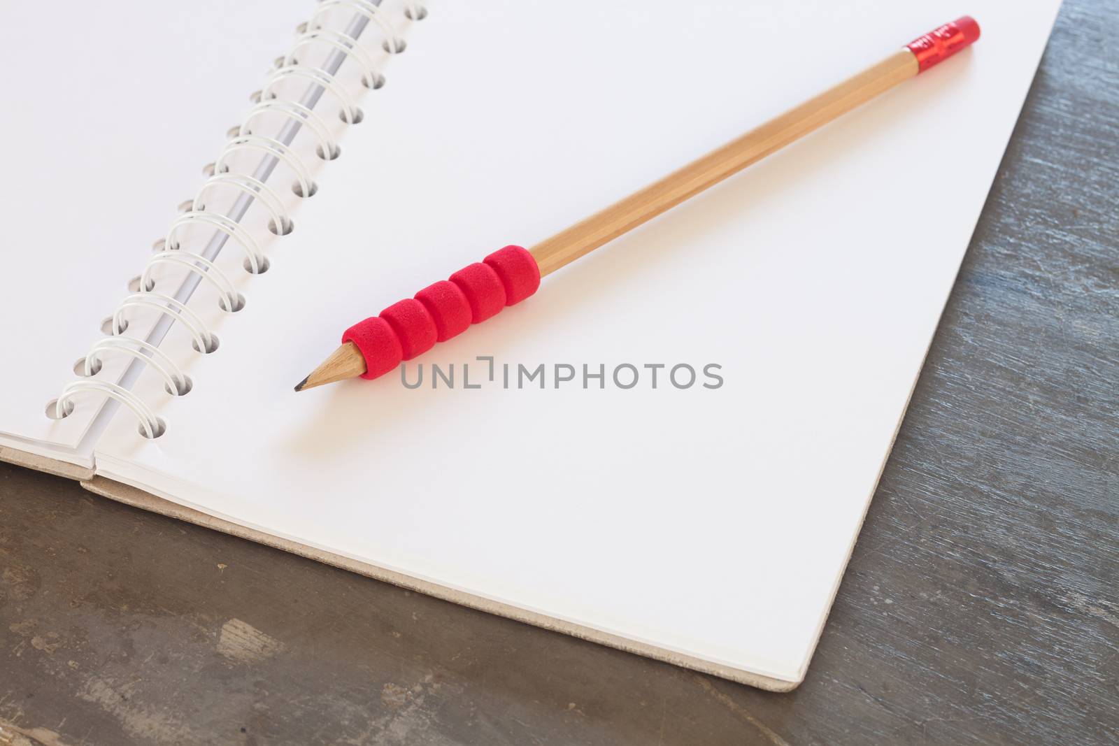 Blank notebook with pencil on grey background, business concept