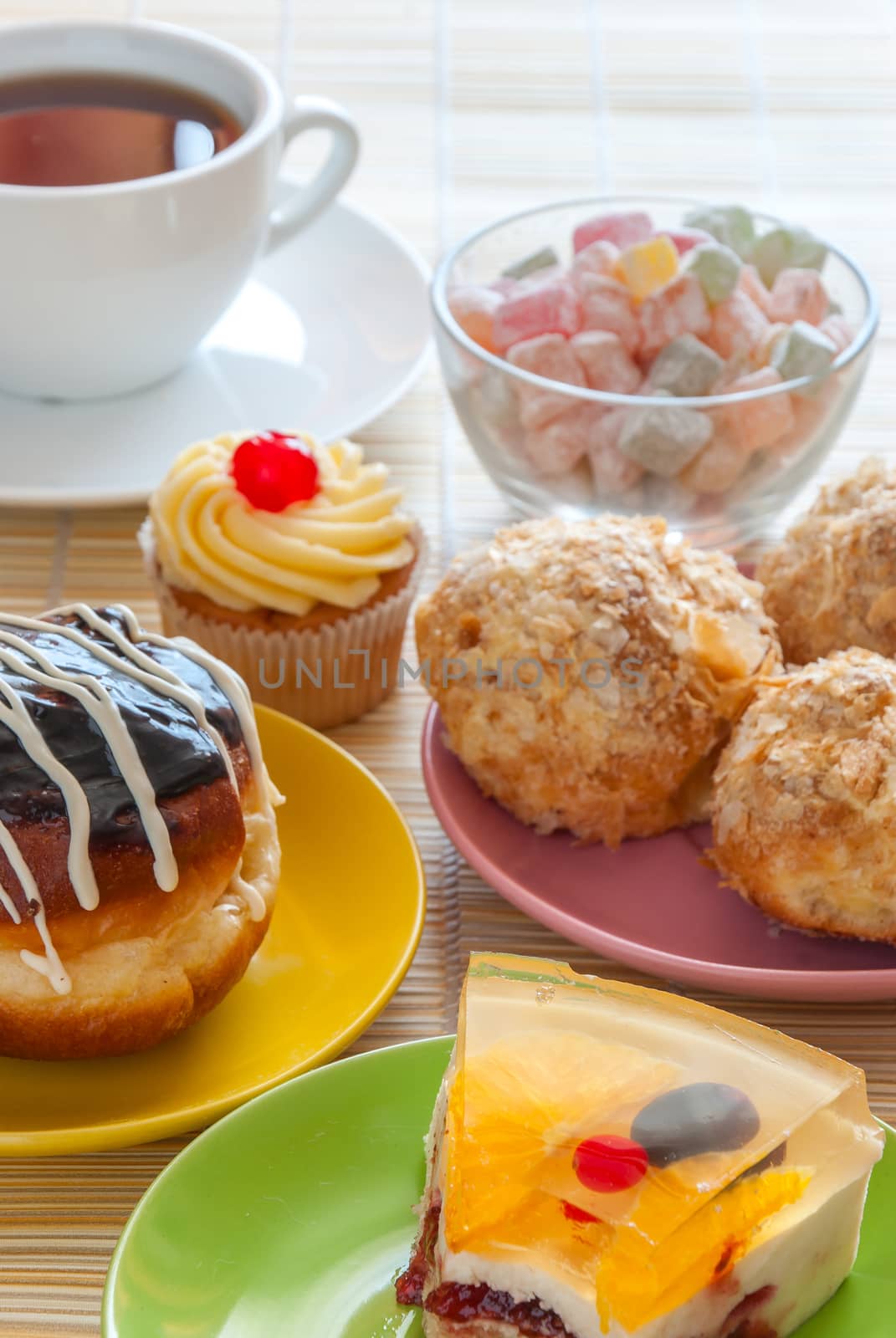 Tea, fresh cherry muffin, colorful delight, eclair and doughnut, various sweet dessert