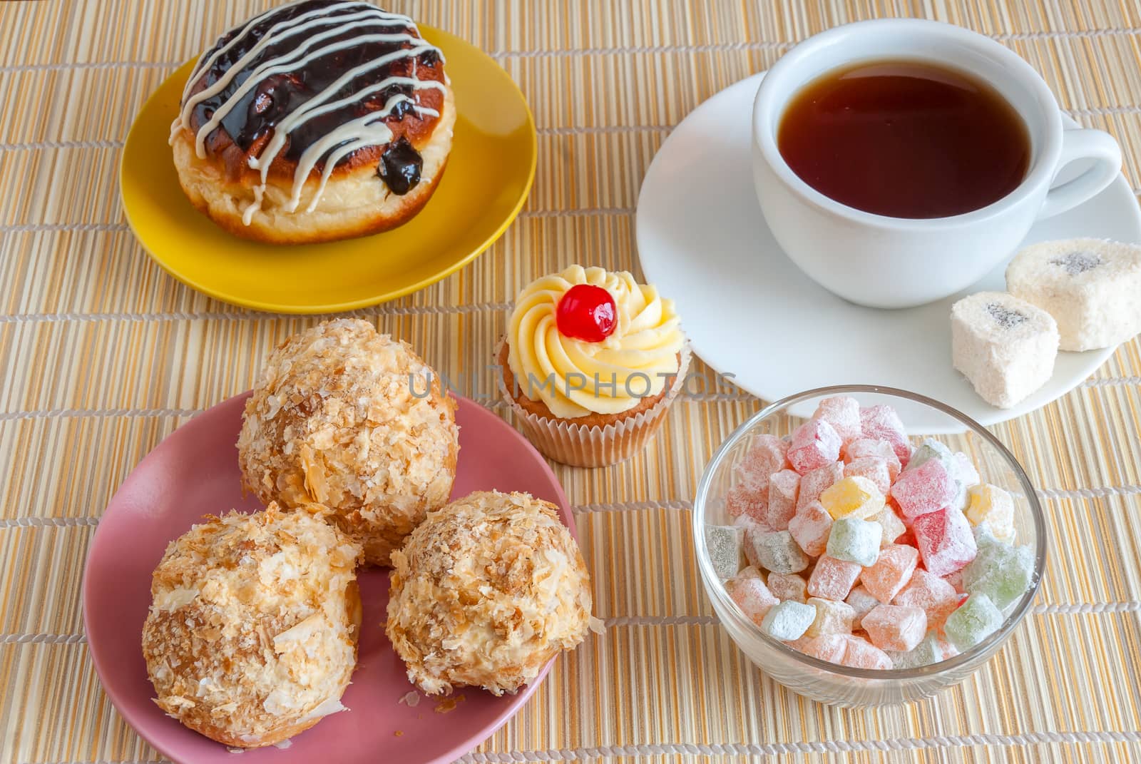 Tea, fresh cherry muffin, colorful delight, eclair and doughnut, various tasty sweet dessert