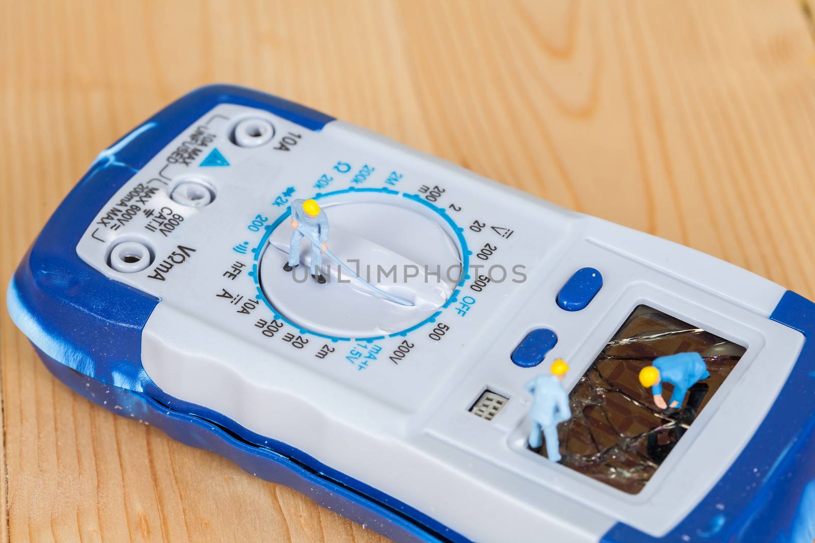 miniature maintenance team repairing a broken Digital multimeter