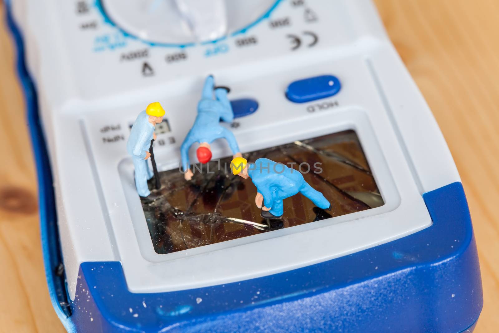 miniature maintenance team repairing a broken Digital multimeter