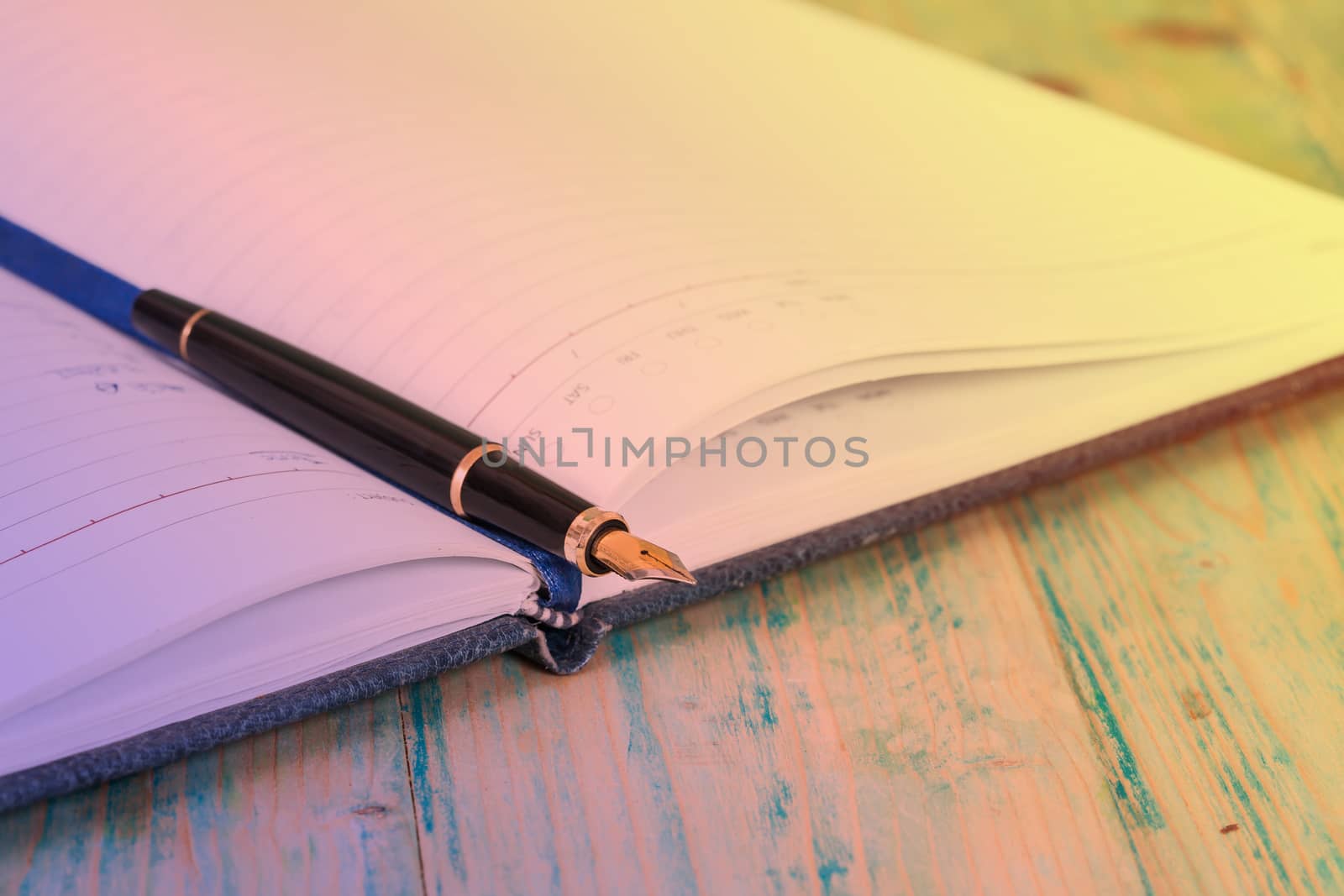 selective focus of the  pen on opened lined diary book , 
extremely shallow DOF