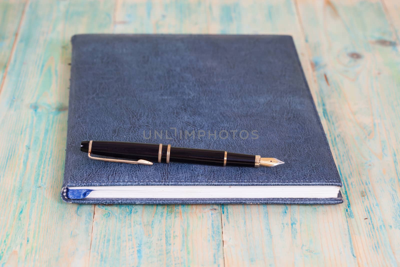 Diary with  pen  on wood background
