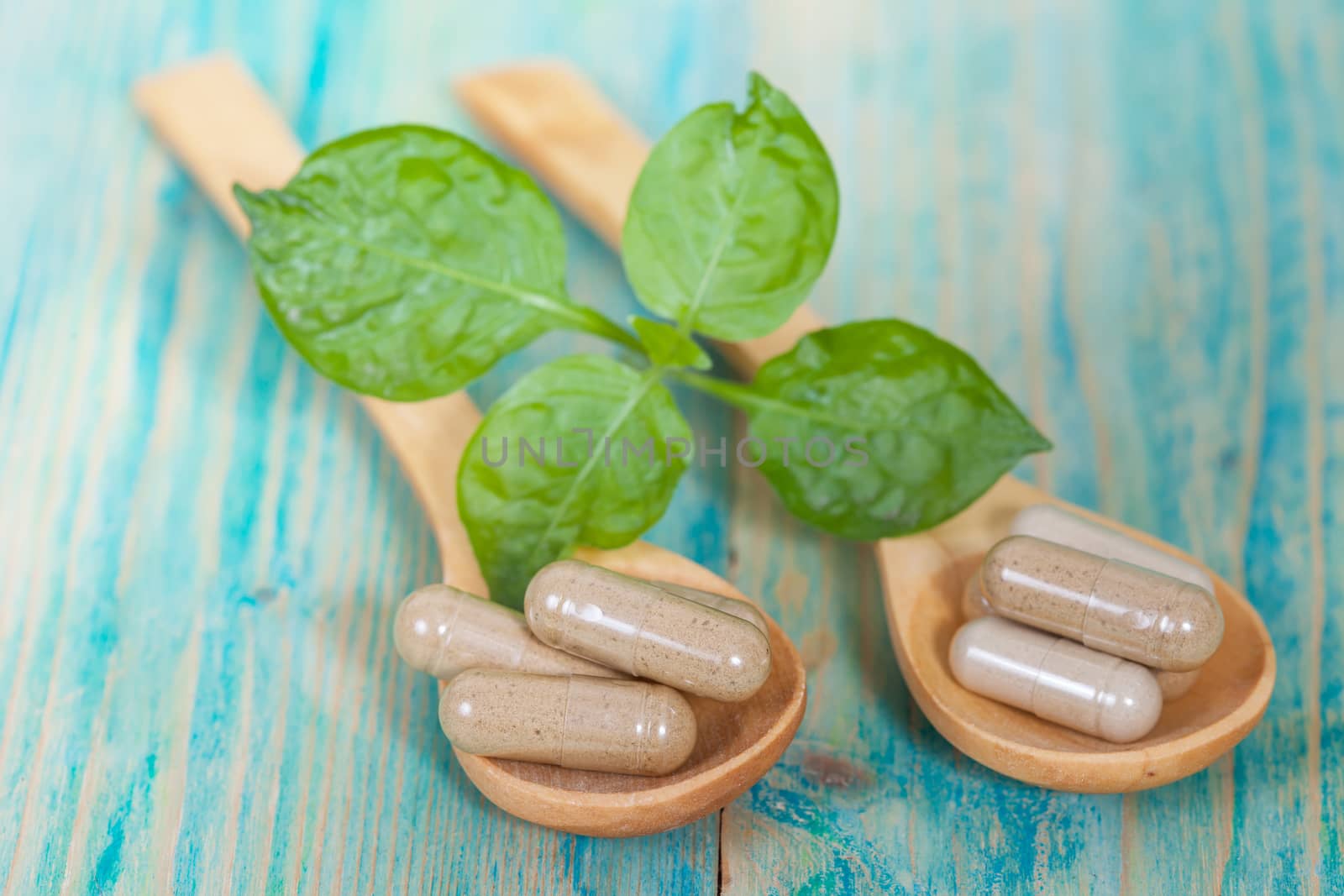 Capsules of herbs on spoon. healthy eating for healthy living.