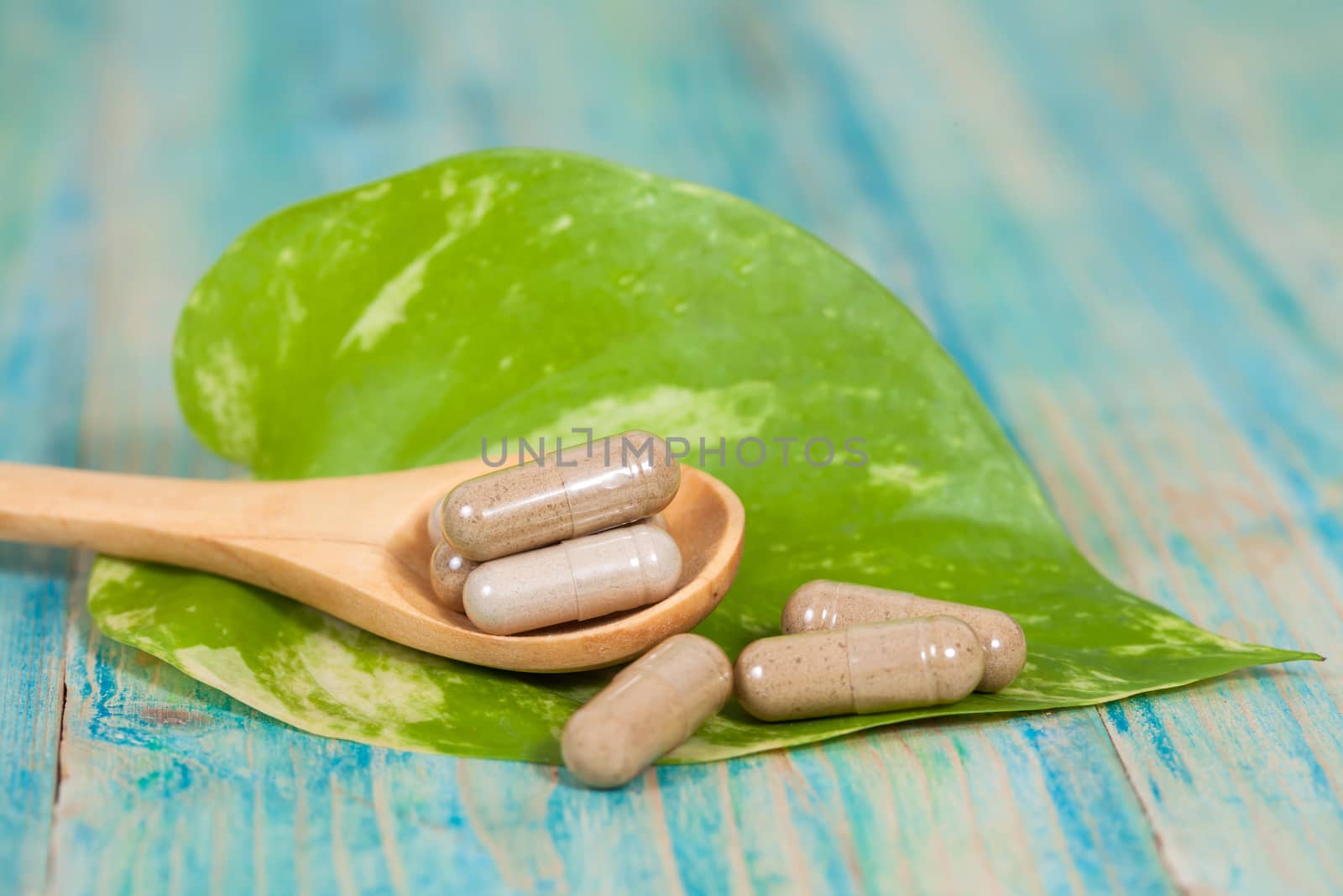 Capsules of herbs on spoon. healthy eating for healthy living.