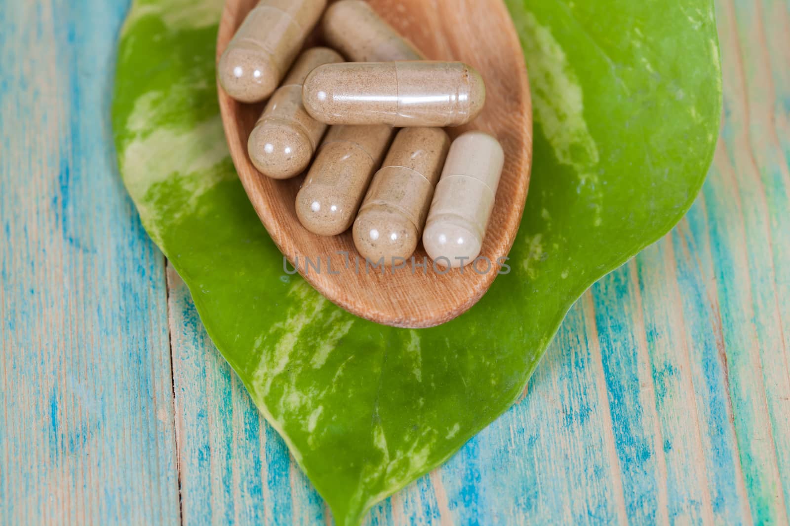 Capsules of herbs on spoon. healthy eating for healthy living.