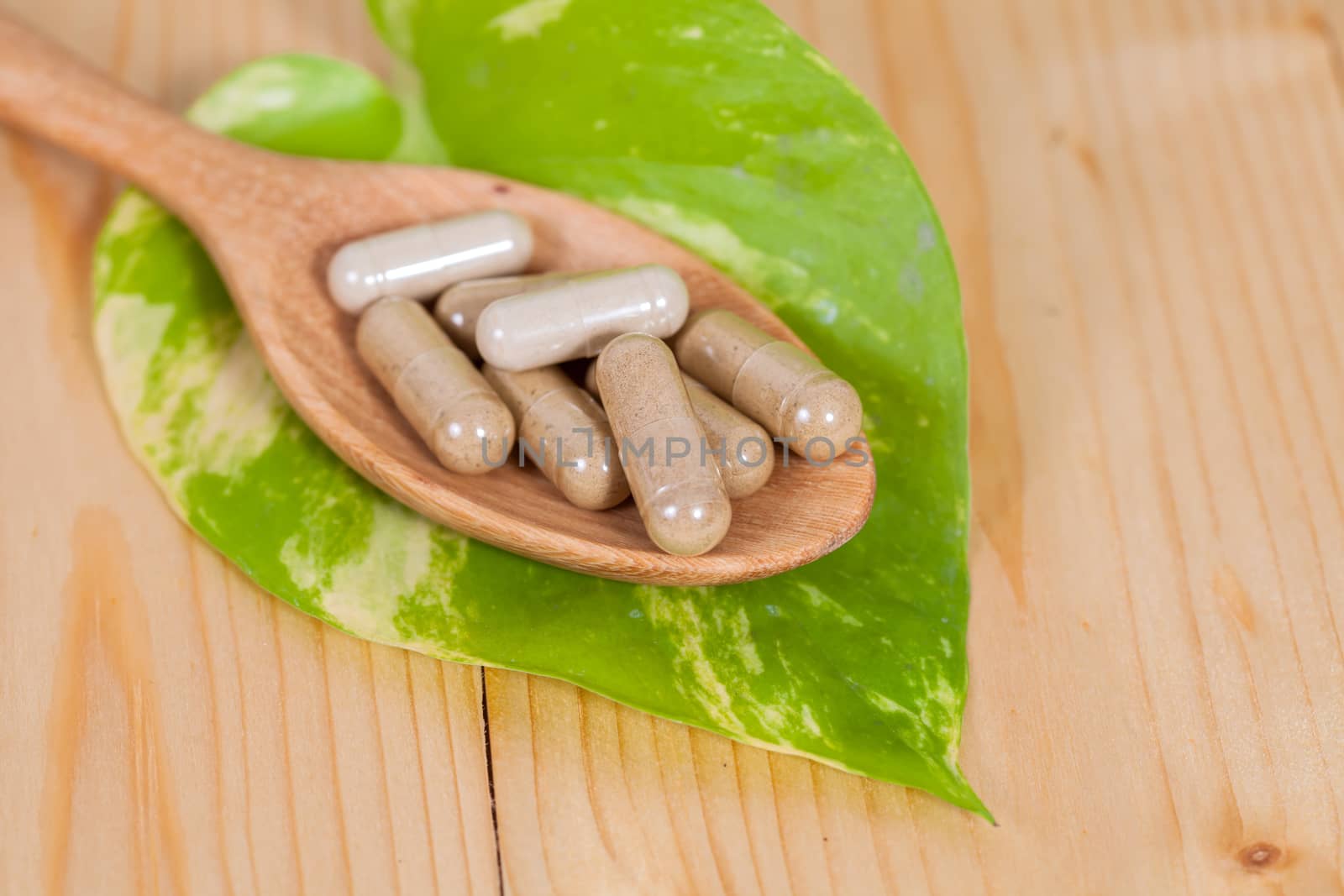 Capsules of herbs on spoon. healthy eating for healthy living.
