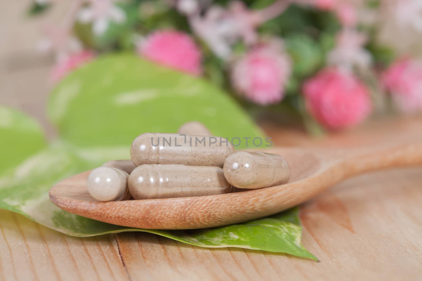 Capsules of herbs on spoon. healthy eating for healthy 
living.