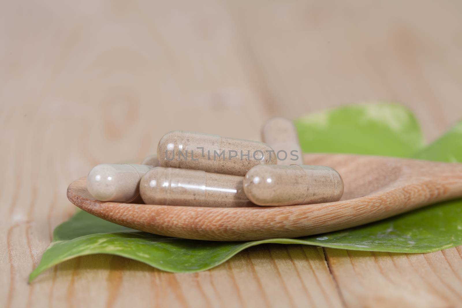 Capsules of herbs on spoon. healthy eating for healthy 
living.
