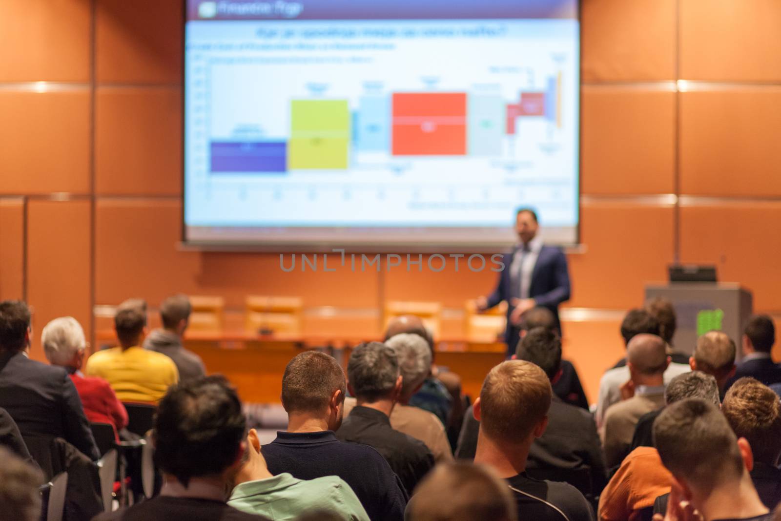 Speaker giving a talk in conference hall at business event. Audience at the conference hall. Business and Entrepreneurship concept.