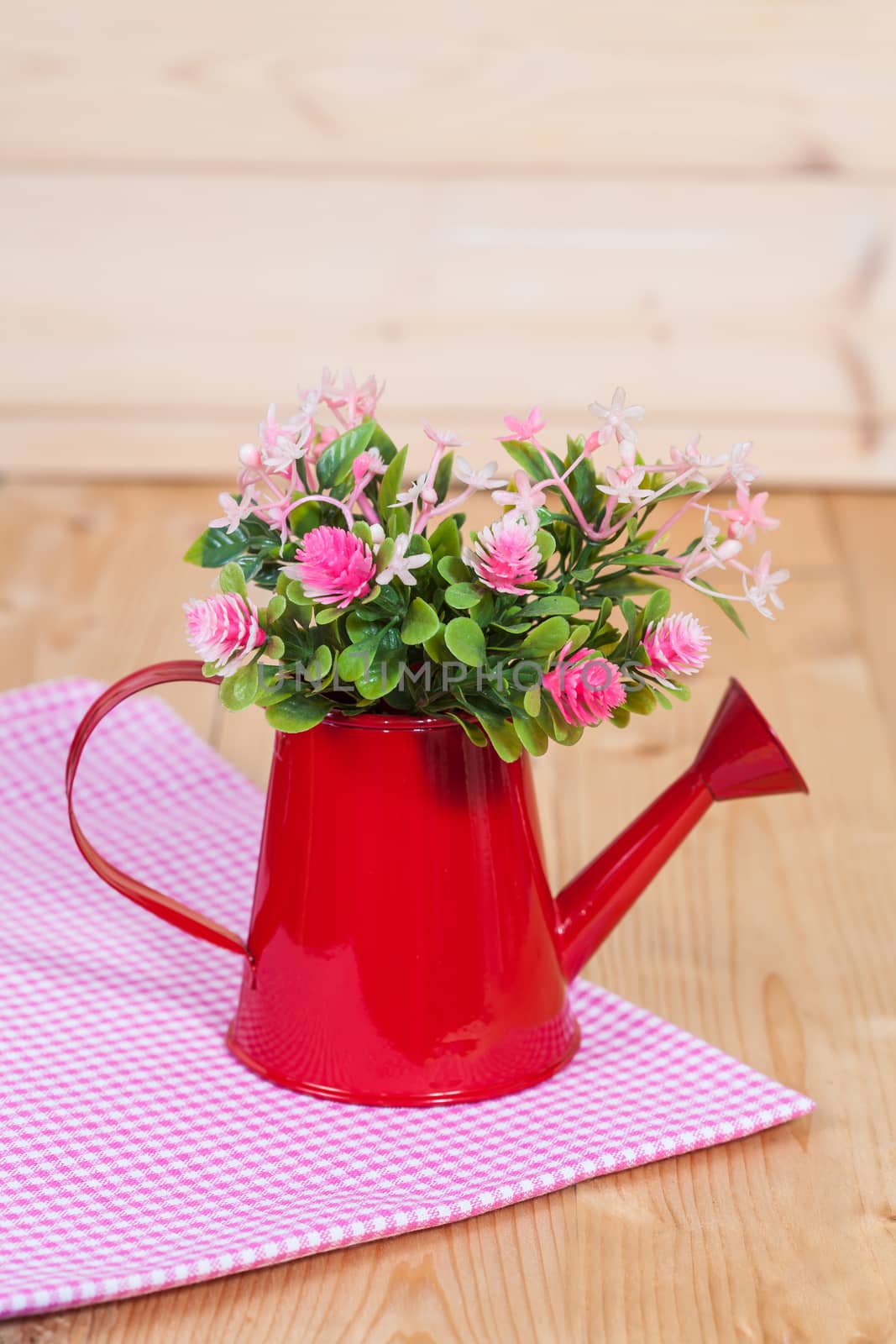 flowers in red watering on wood