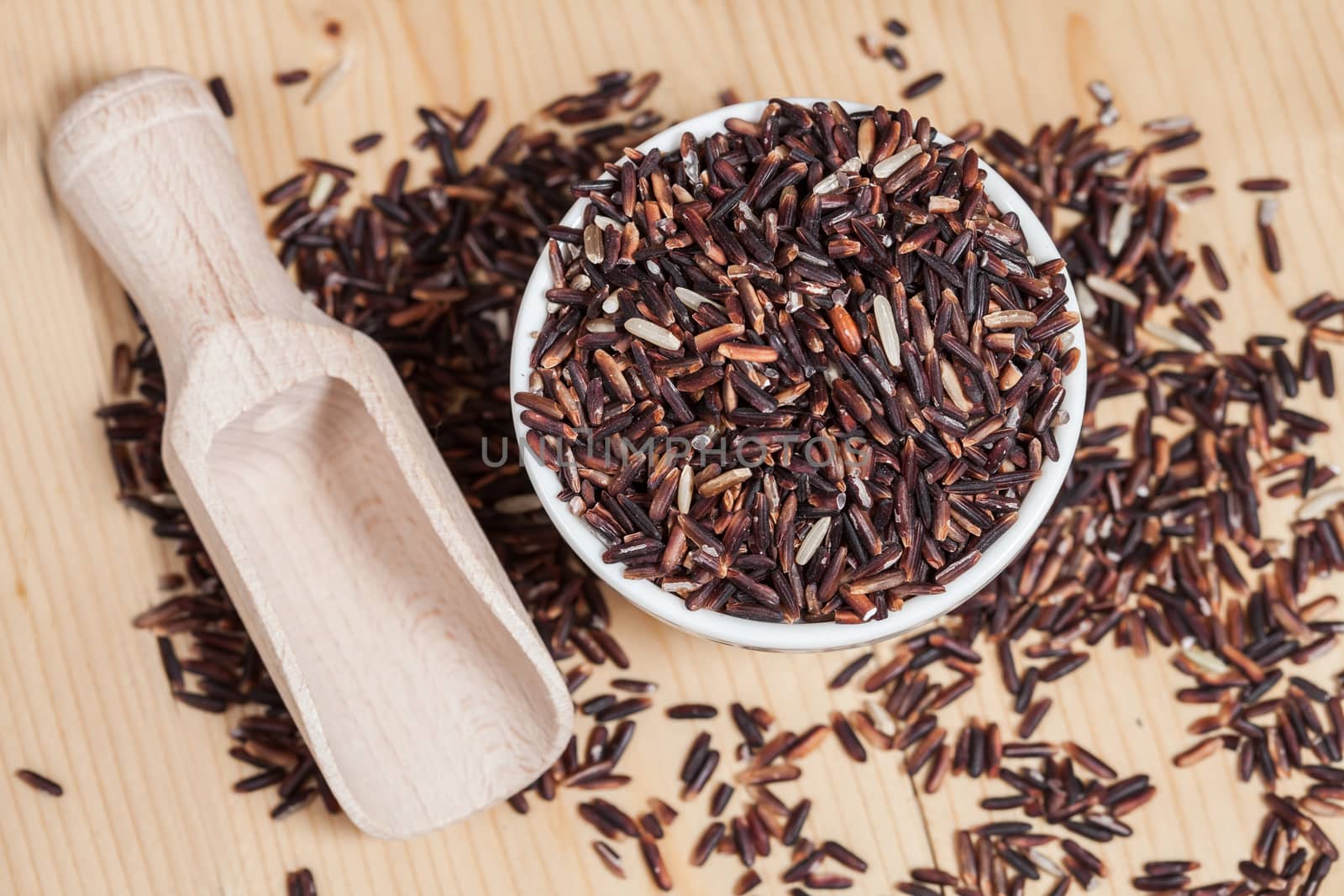 Rice berry in bowl on wood background