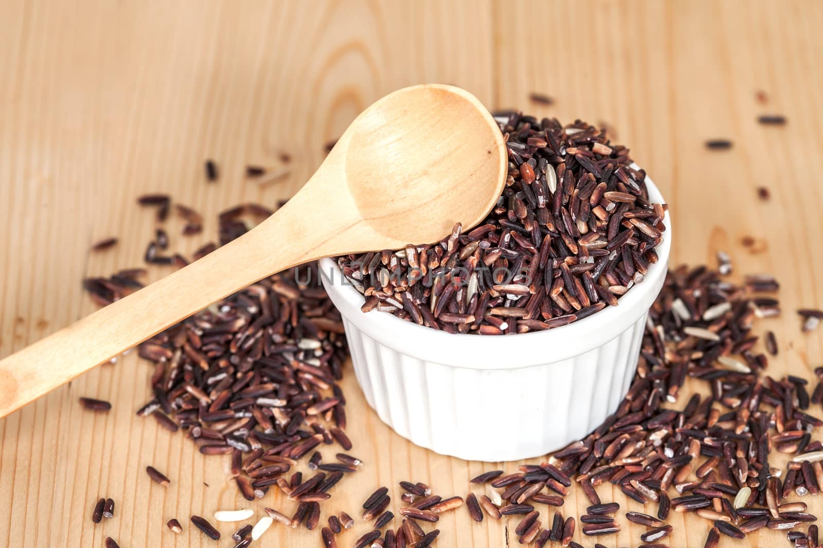Rice berry in bowl on wood background