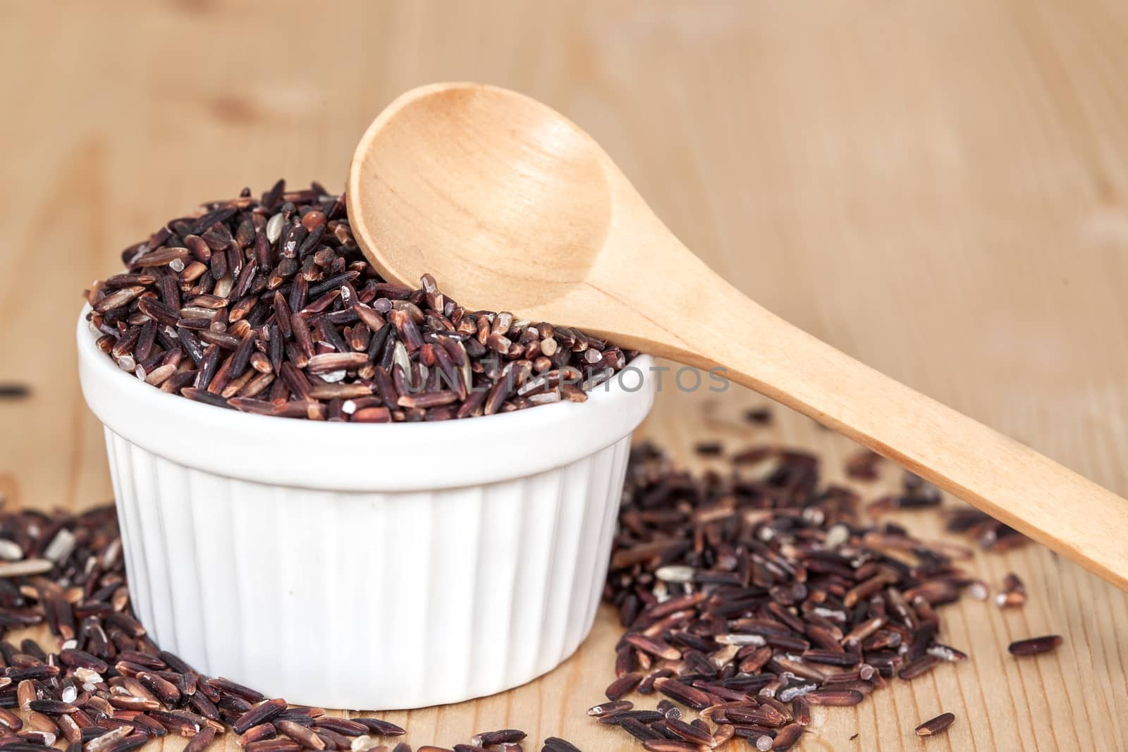 Rice berry in bowl on wood background