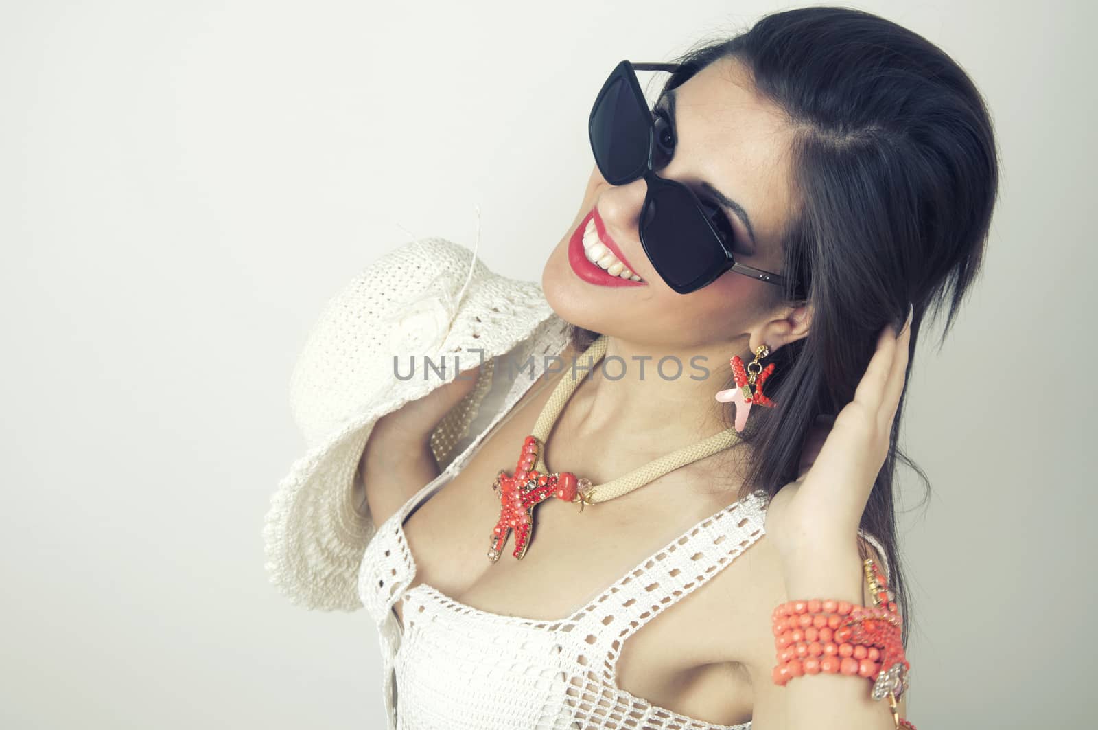 Woman smiling with perfect smile wearing sunslusses and jewlry