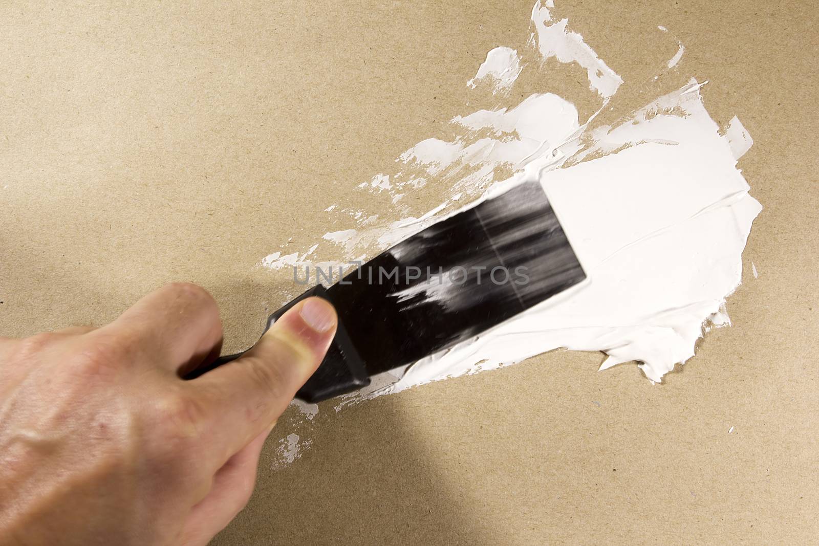 Putty Knife with Spackling Paste to Repair Wall Damage