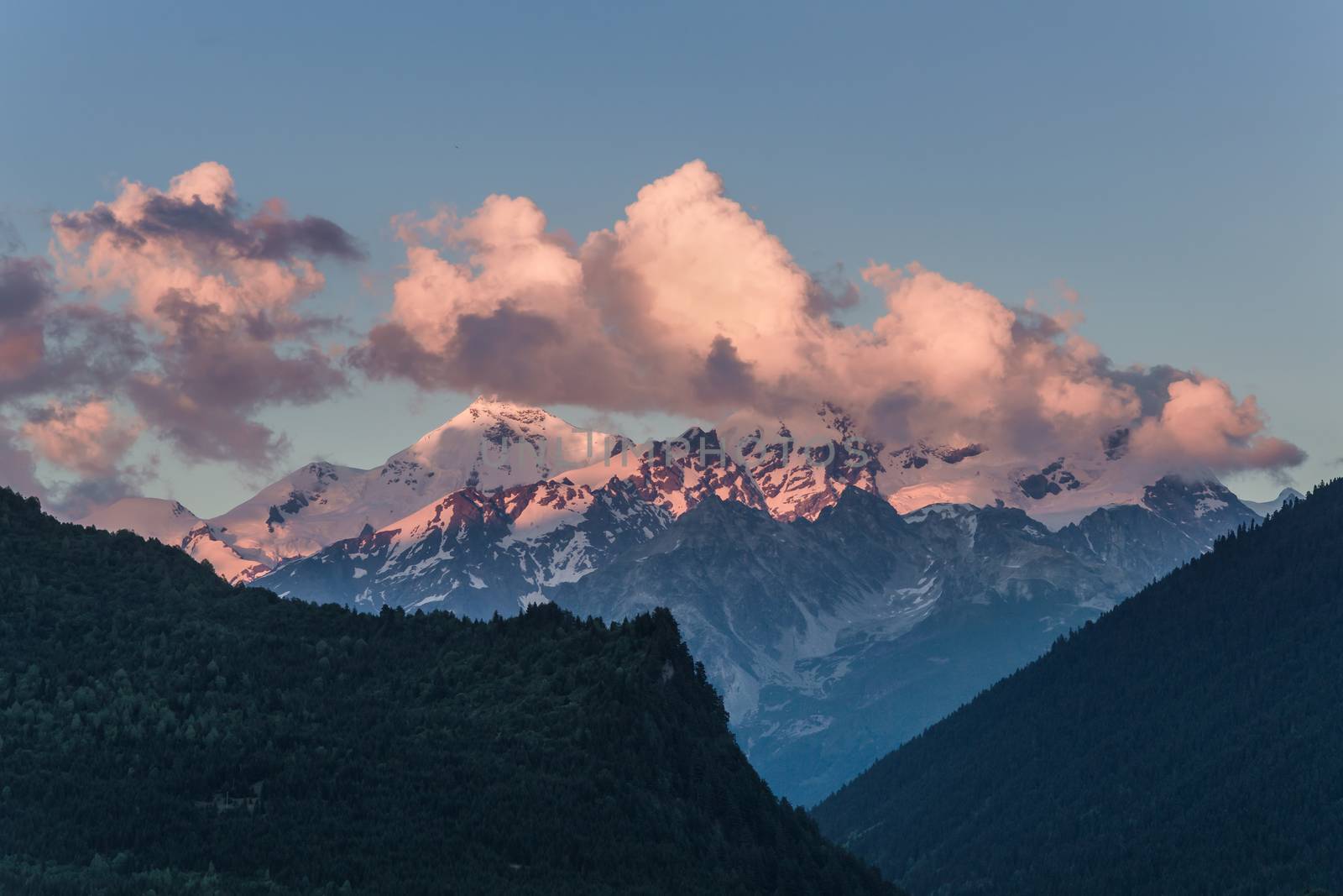 Big mountains in clouds on sunset