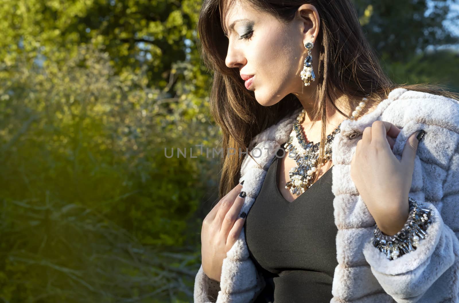 Outdoor fashion portrait of glamour lady with jewelry posing at sunset. Attractive sexy and young girl
