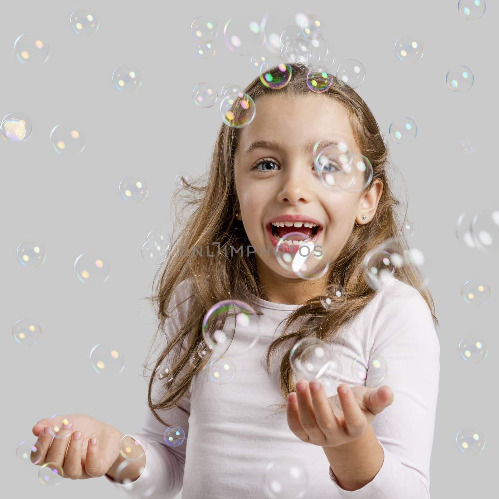 Girl playing with soap bubbles by Iko