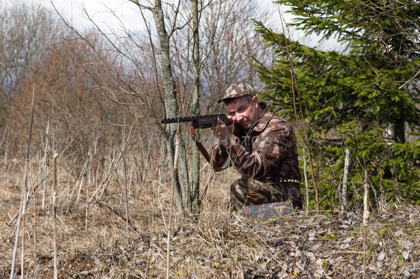 Outdoor shot of man aiming a shotgun.