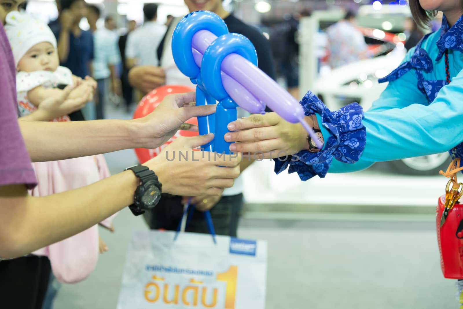 Adults give balloons to children