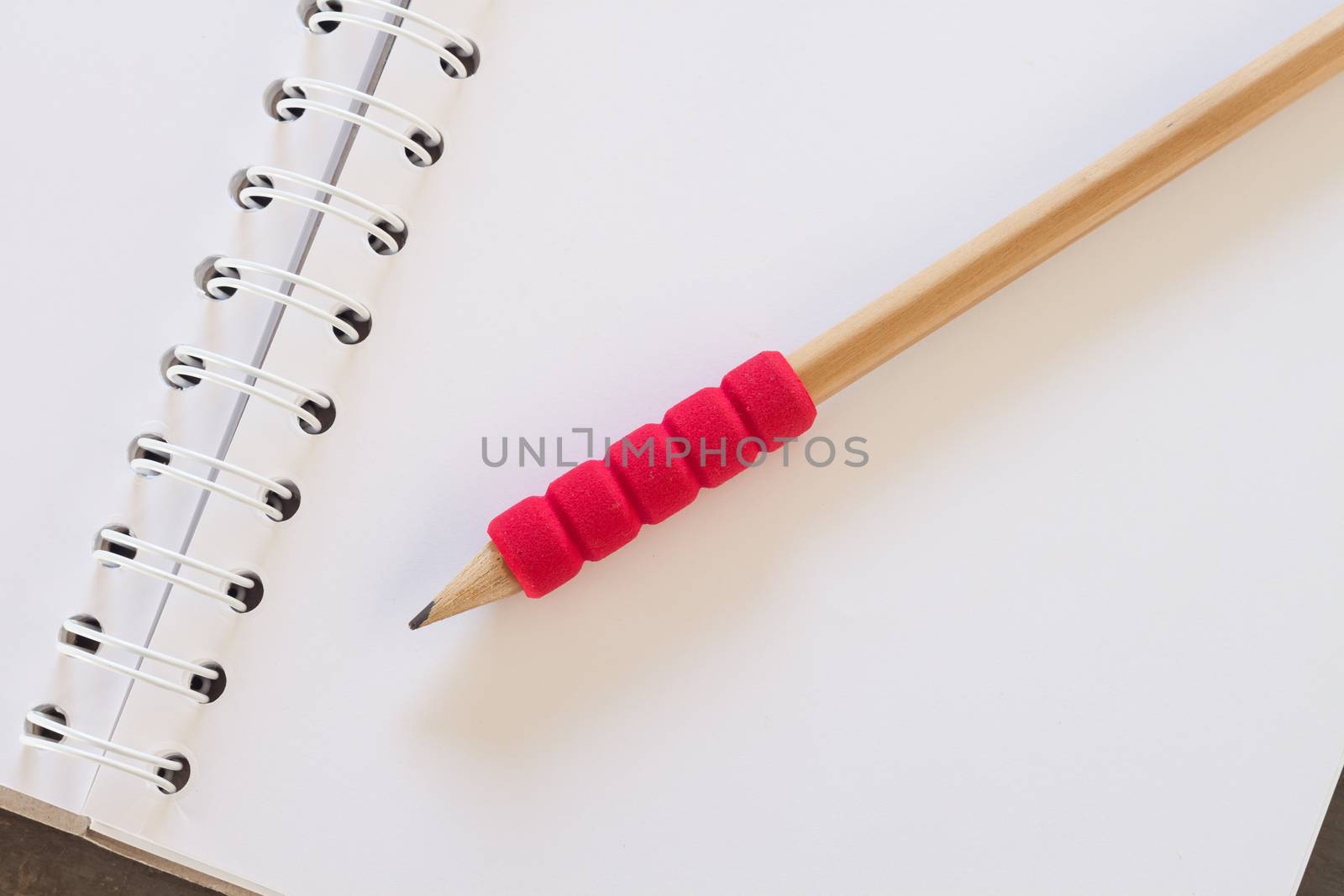 Blank notebook with pencil on grey background, business concept