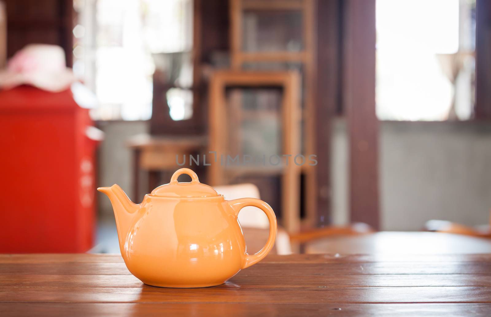 Tea pot on wooden table in coffee shop