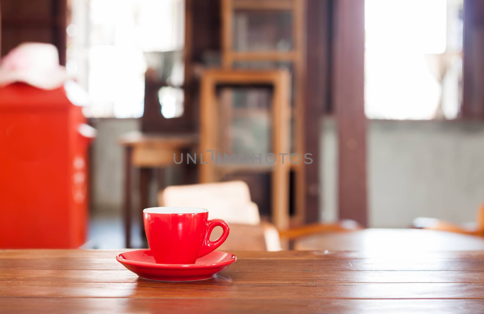Red coffee cup on wooden table in coffee shop