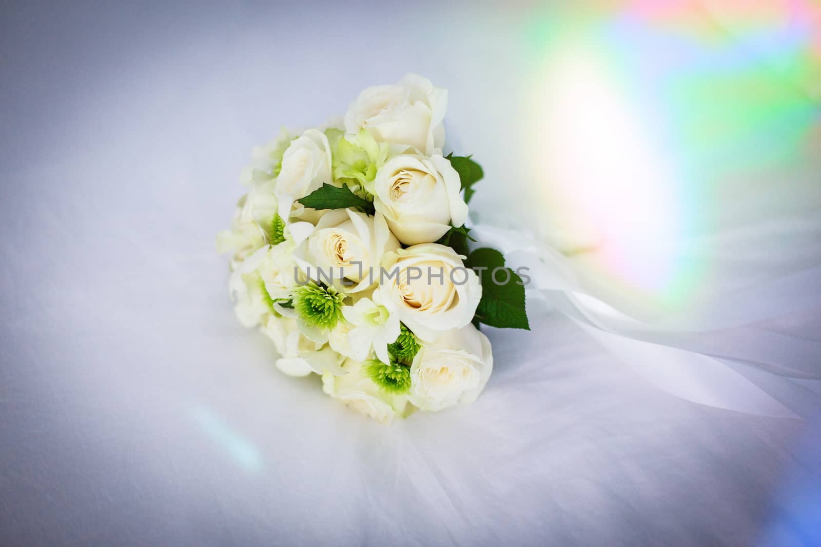 Wedding bouquet of white roses on a white veil