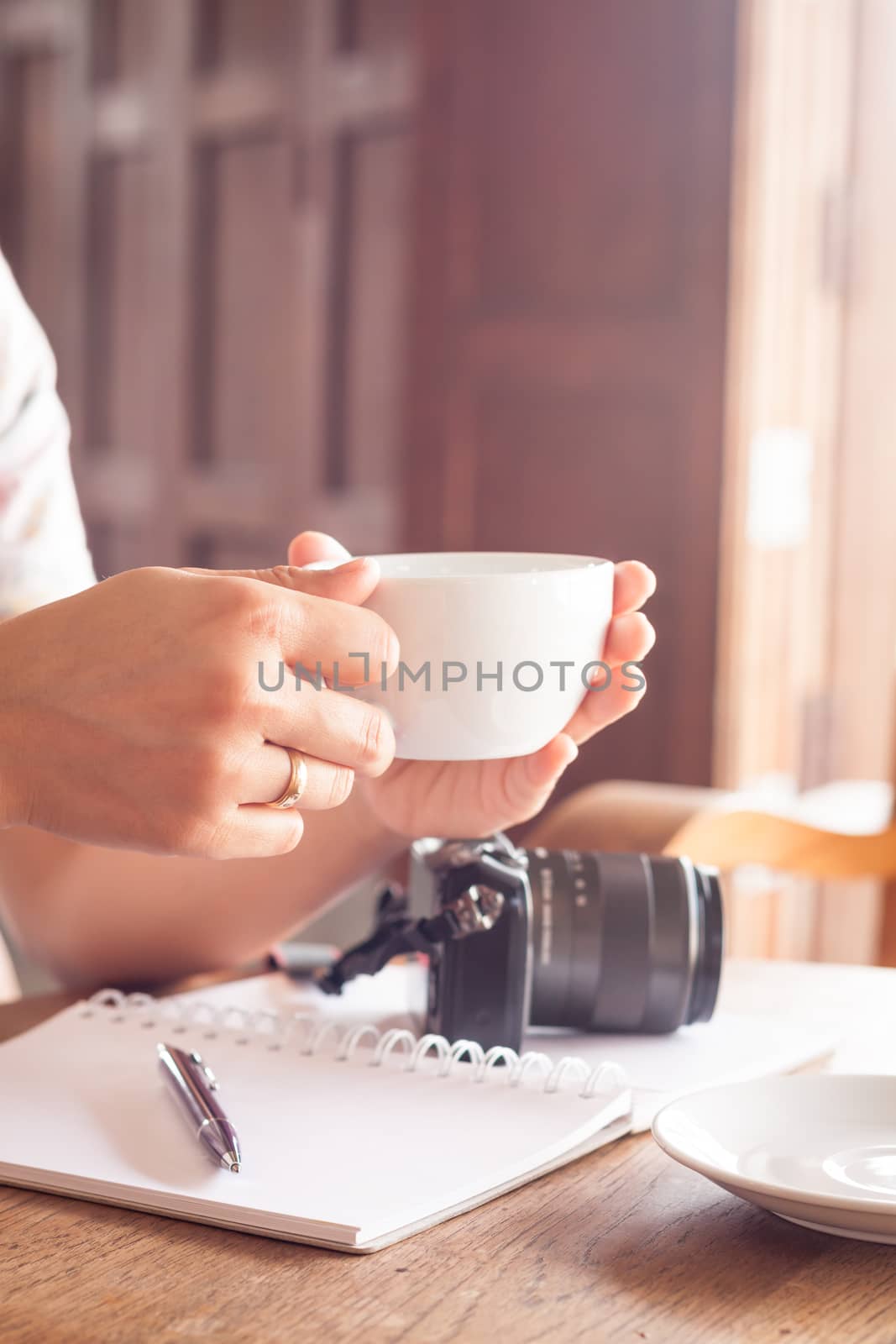 Woman with cup of coffee in coffee shop, stock photo