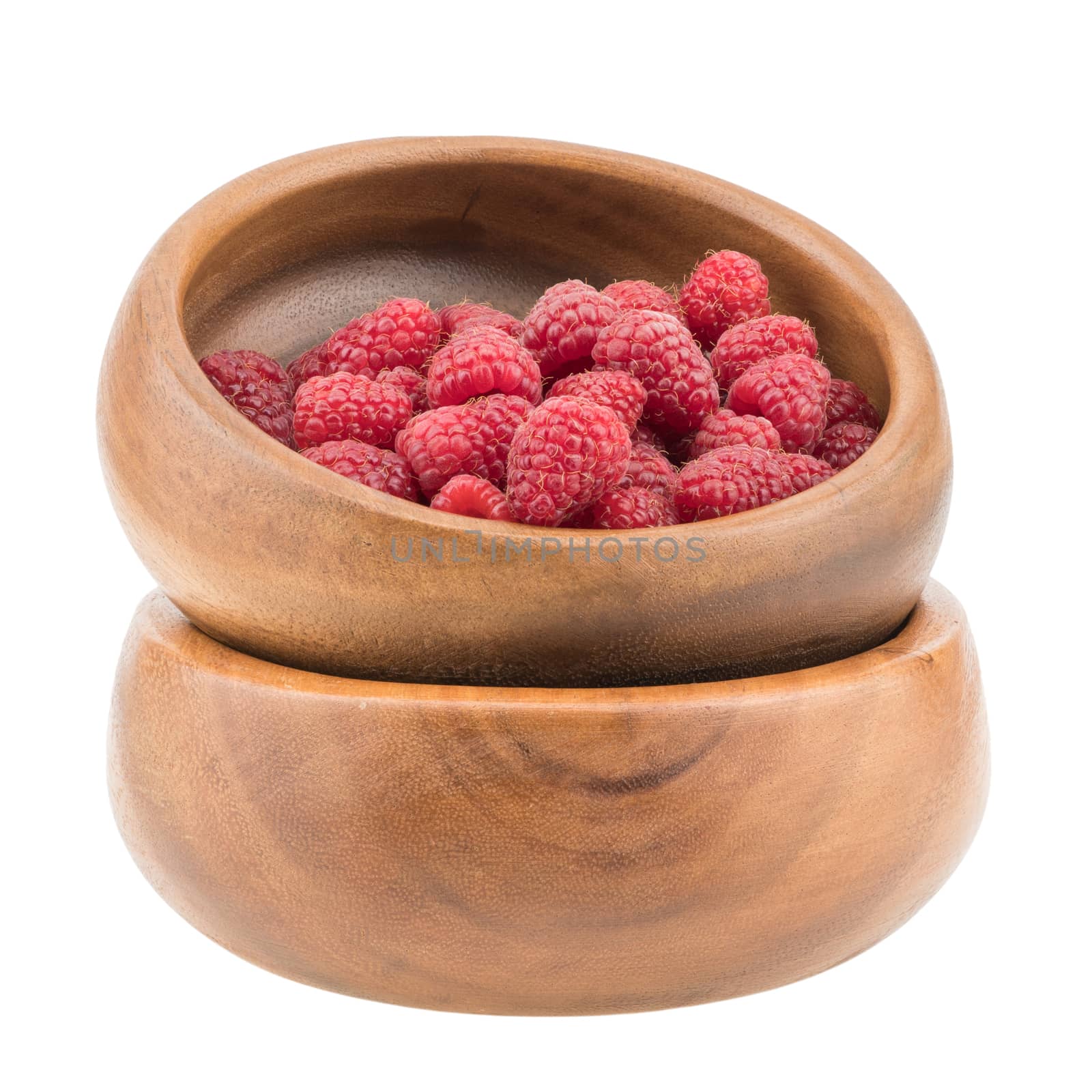 Raspberries in a wooden bowl. Ripe and tasty raspberries isolated on white background. Selective focus.