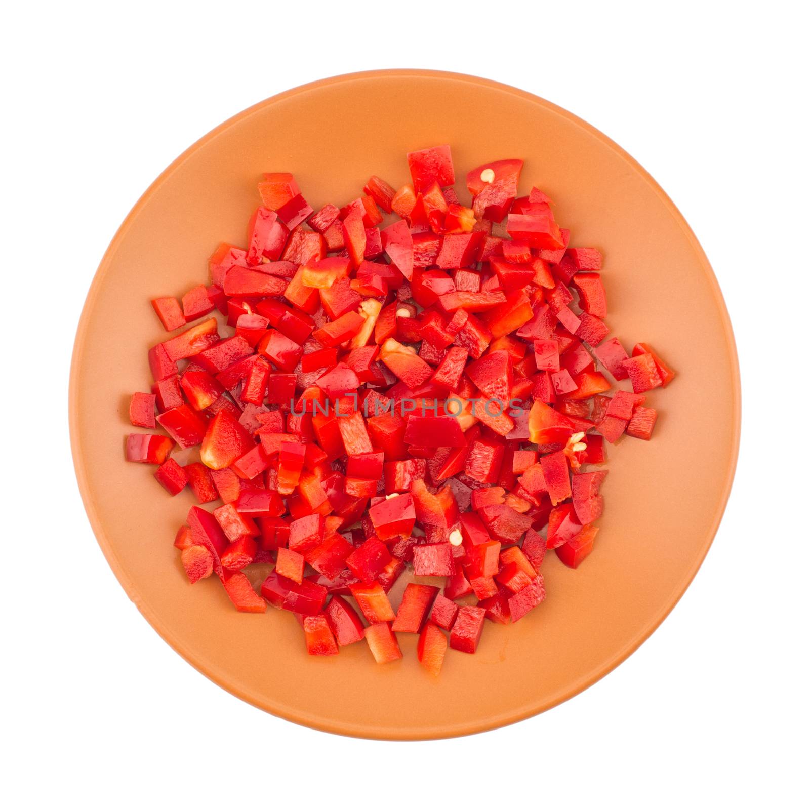 Sliced red pepper in a brown ceramic plate. Isolated on white background. Top view.