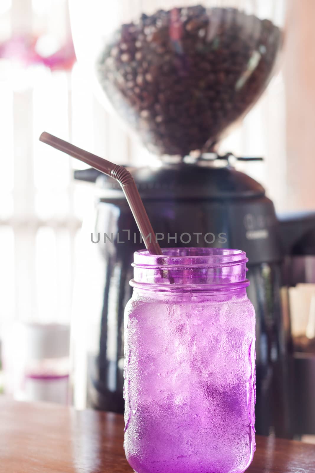 Iced drink in violet glass in coffee shop, stock photo