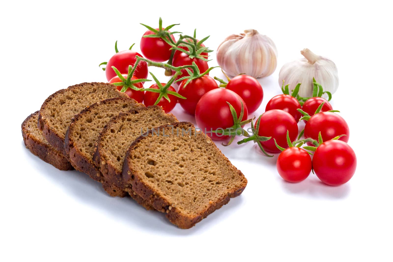 Composition of black bread slices, cherry tomatoes and garlic