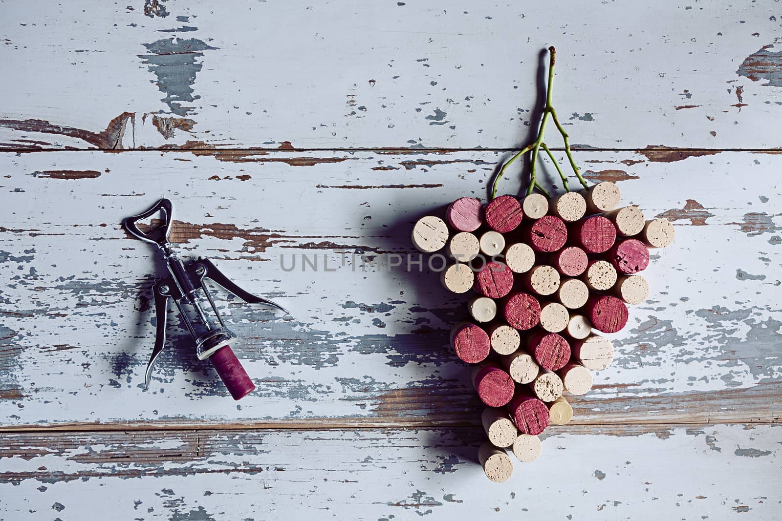 Corks grapes and corkscrew on wood background