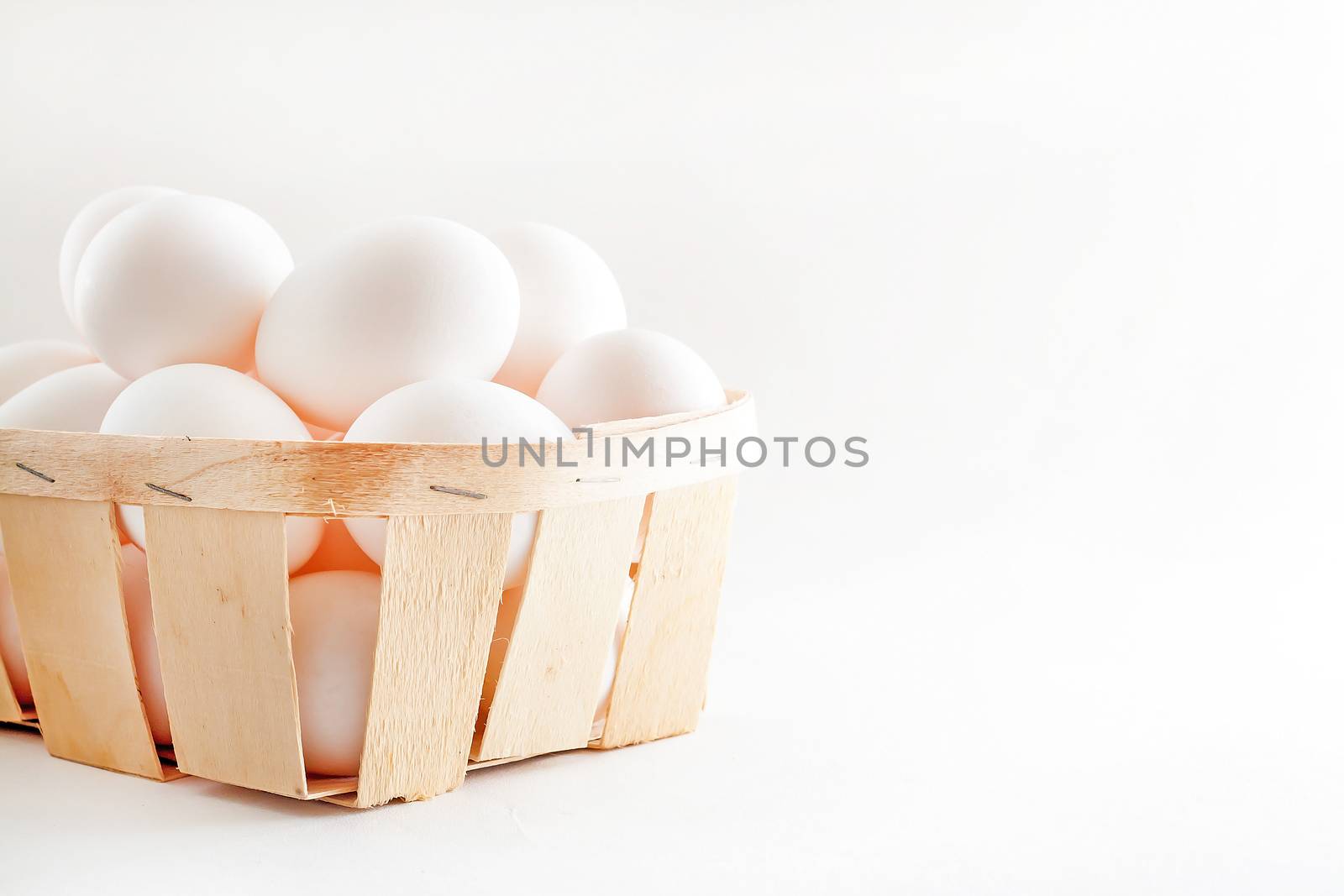 full basket of fresh eggs on a white background/