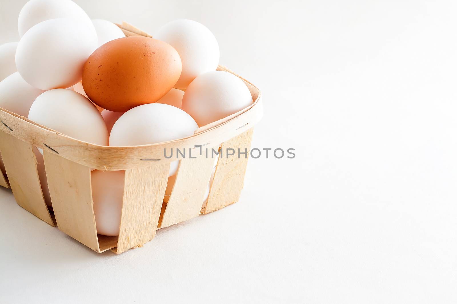 full basket of fresh eggs on a white background/