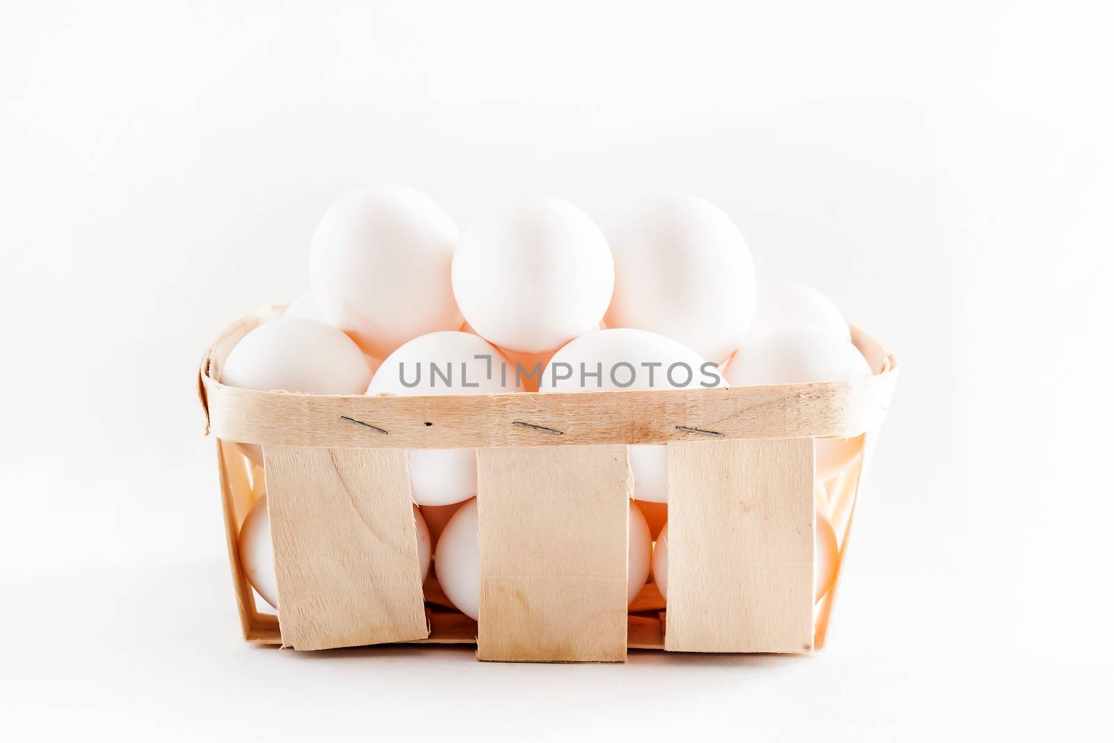 full basket of fresh eggs on a white background/